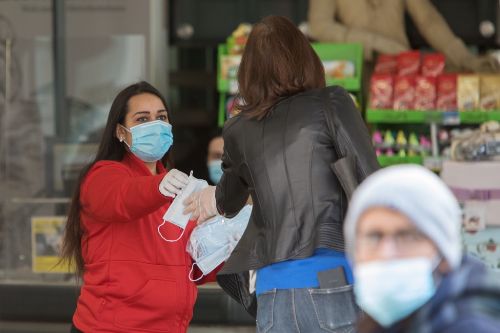 Eine Supermarkt-Mitarbeiterin verteilt Masken im österreichischen Wien (Bild: Alex Halada/AFP)