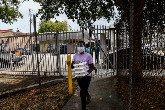 Freiwilliger mit Schutzmaske liefert Essen in Miami (Bild: Chandan Khanna/AFP)