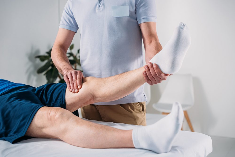 Schnappschuss von Physiotherapeut, der Seniorin Bein auf Massagetisch massiert (© Bildagentur PantherMedia / AllaSerebrina)