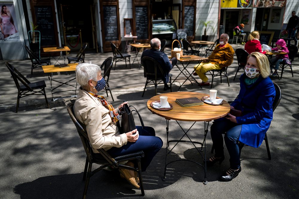 Caféterrasse und Gäste mit Mundschutz