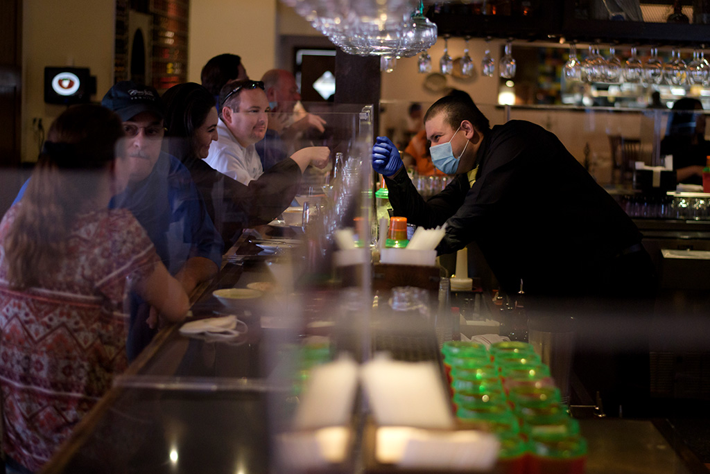 Texas lockert Corona-Schutzmaßnahmen: Kellner und Kunden in einer Bar in Houston (Bild: Mark Felix/AFP)
