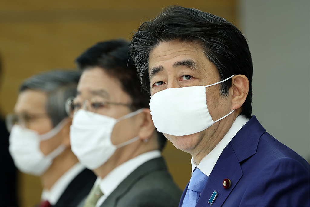 Japans Regierungschef Shinzo Abe (r.) bei einer Sitzung zur Corona-Krise in Tokio (Bild: STR/JIJI PRESS/AFP)