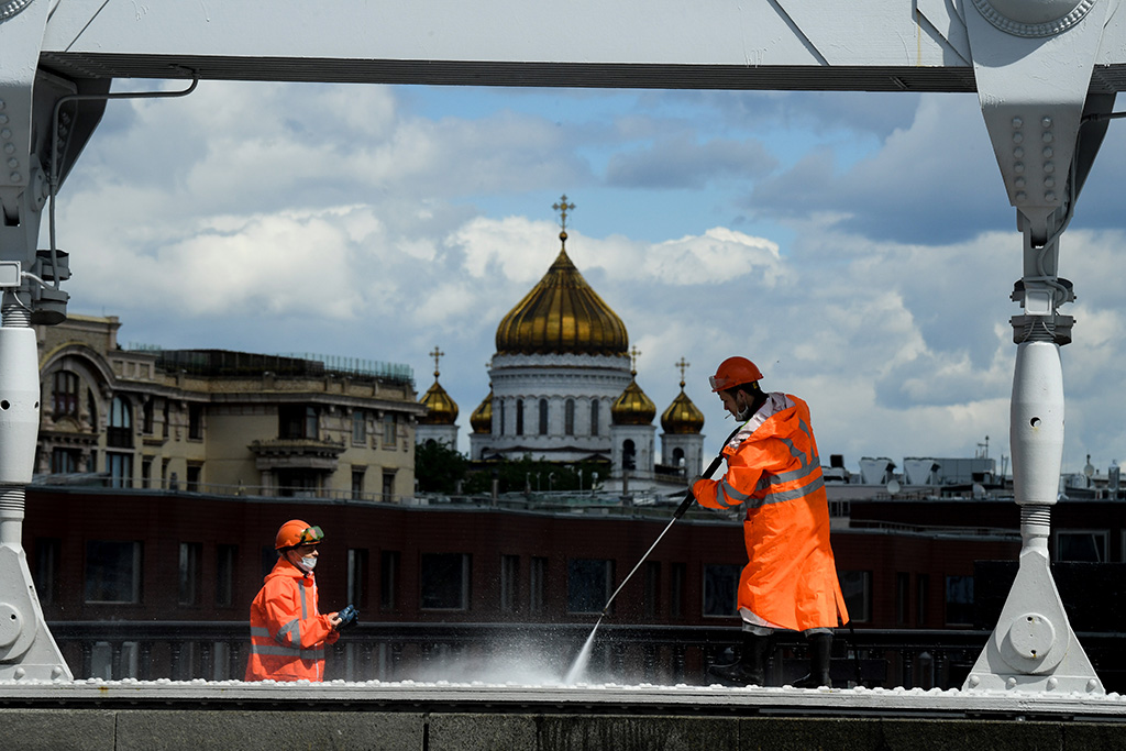 Arbeiter der Stadt Moskau in Schutzkleidung reinigen die Krymsky-Brücke (Bild: Kirill Kudryavisev/AFP)