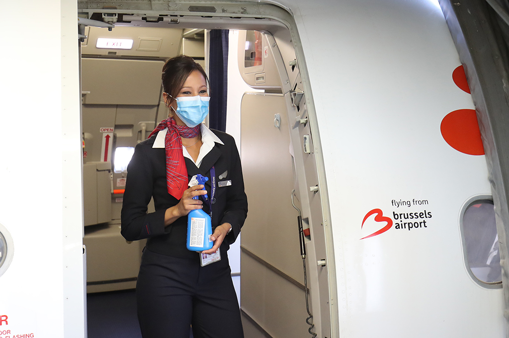 Stewardess mir Desinfektionsgel am Eingang eines Flugzeuges von Brussels Airlines (Bild: Bruno Fahy/Belga.)