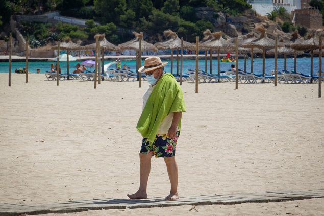 Urlauber mit Maske am Strand von Mallorca (Bild: Jaime Reina/AFP)