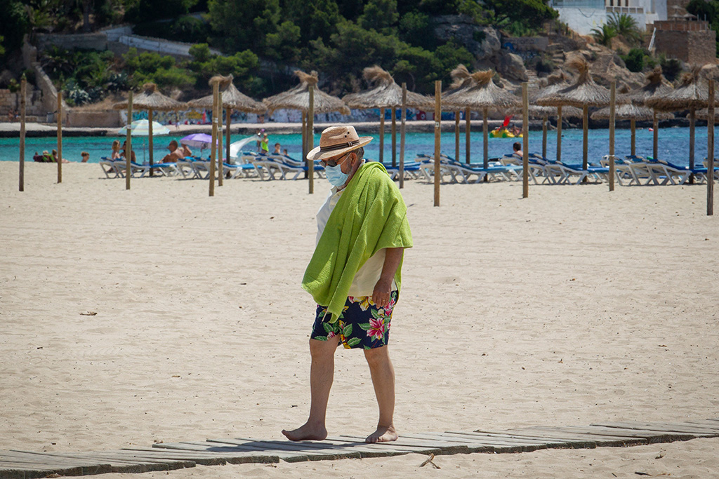 Urlauber mit Maske am Strand von Mallorca (Bild: Jaime Reina/AFP)