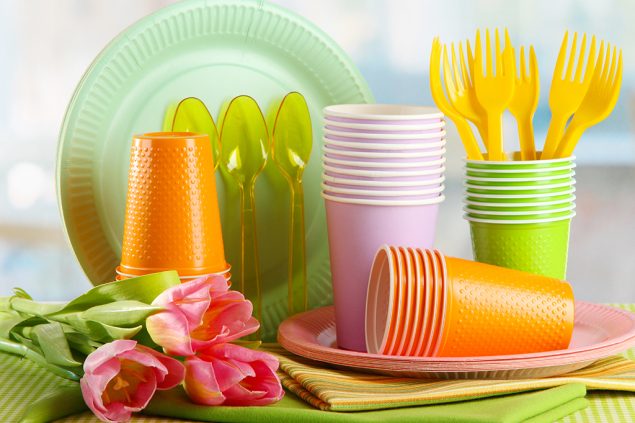 Buntes Plastikgeschirr auf Tisch mit Tulpen in Großaufnahme (© Bildagentur PantherMedia / belchonock)
