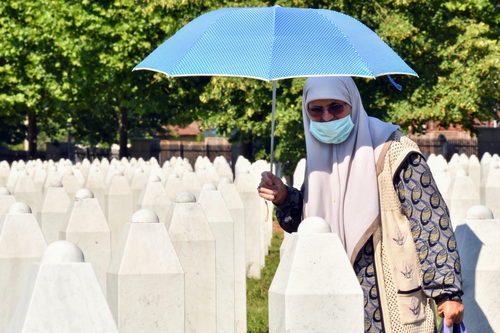 Überlebende des Massakers in Srebrenica von 1995 geht zwischen Gräbern von Verwandten hindurch (Bild: Elvis Barukcic/AFP)