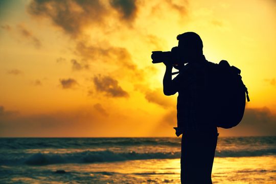 Fotograf am Meer im Sonnenuntergang