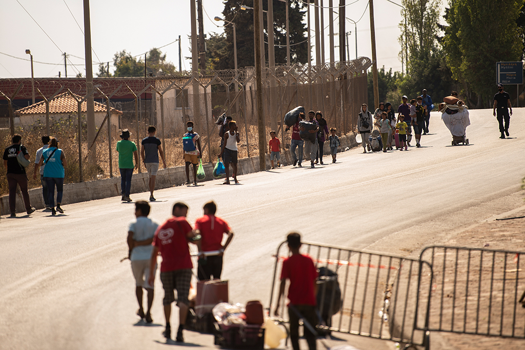 Migranten betreten das neue Lager auf Lesbos (Bild: Angelos Tzortzinis/AFP)