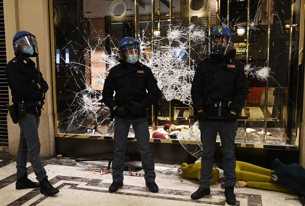 Polizisten vor kaputten Schaufenstern in Turin (Bild: Marco Bertorello/AFP)