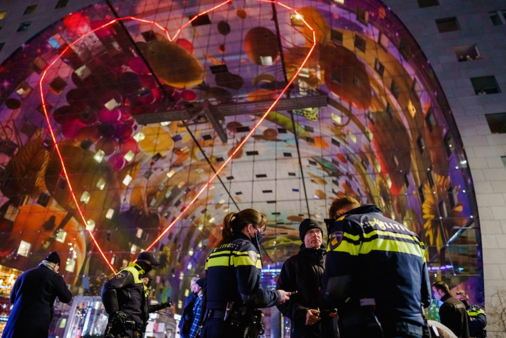 Polizisten kontrollieren Demonstranten in Rotterdam bei einem Protest gegen die Ausgangssperre (Bild: Marco de Swart/ANP/AFP)