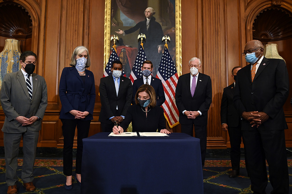 Nancy Pelosi unterschreibt den Beschluss des Repräsentantenhauses (Bild: Brendan Smialowski/AFP)
