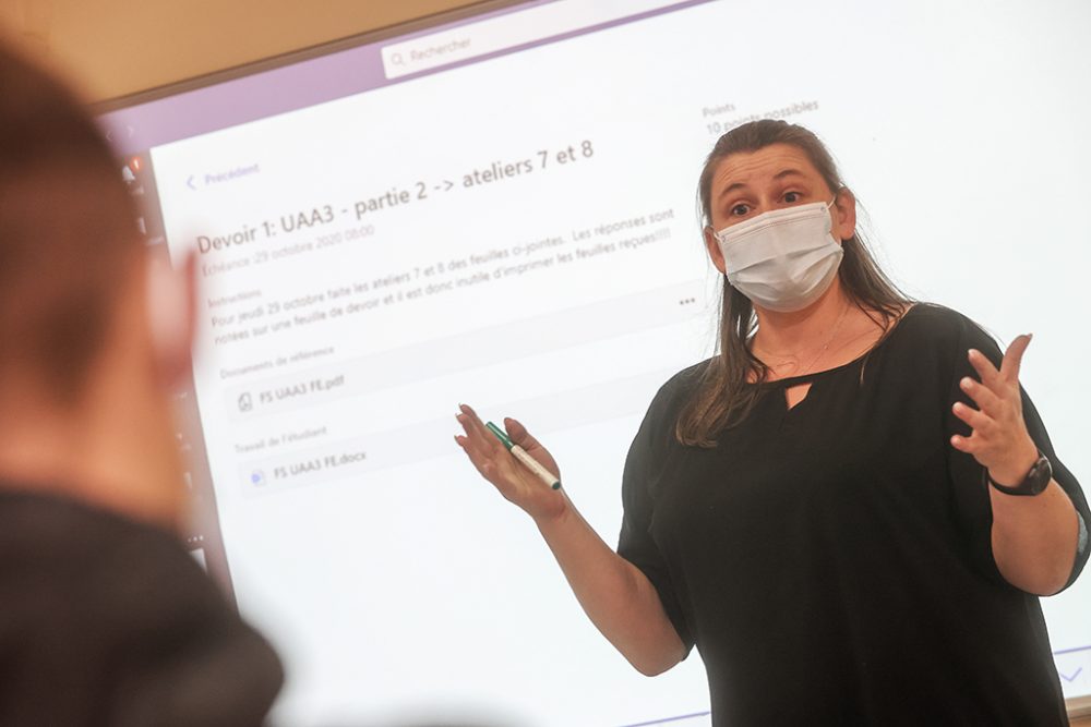 Lehrerin mit Maske im Unterricht vor Schülern