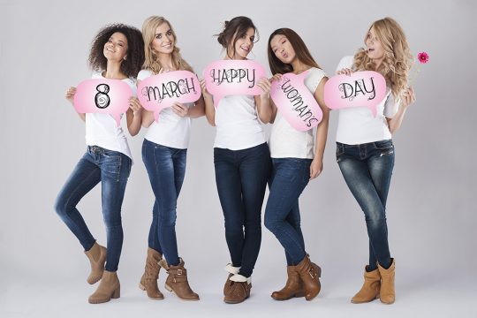 Frauen posieren mit Schildern zum Internationalen Frauentag