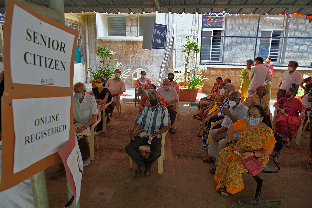 Menschen warten auf ihre Covid19-Impfung im Impfzentrum eines Krankenhauses in Bangalore (Bild: Manjunath Kiran/AFP)