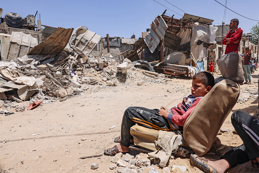 Palästinenser vor ihrem zerstörten Haus in Rafah im südlichen Gazastreifen (Bild: Said Khatib/AFP)
