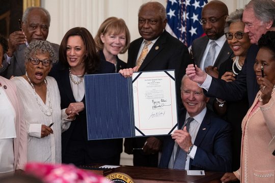 US-Präsident Joe Biden und US-Vizepräsidentin Kamala Harris nach der Unterzeichnung des entsprechenden Gesetzes (Bild: Jim Watson/AFP)