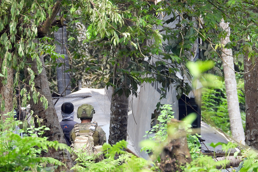 Soldaten neben der auf der philippinischen Insel Jolo abgestürzten Militärmaschine (Bild: Nickee Butlangan/AFP)
