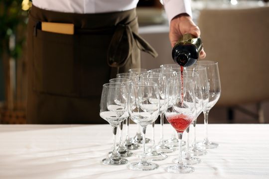 Kellner schenkt Wein in Gläser ein (Bild: © Bildagentur PantherMedia / belchonock)