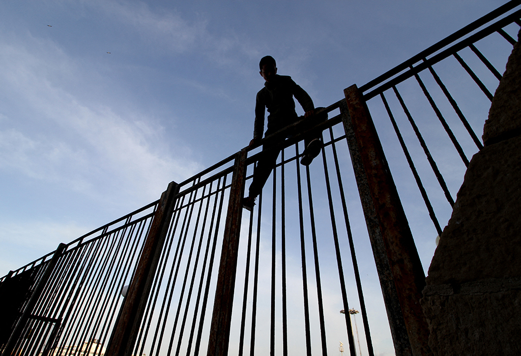 Marrokanischer Junge klettert am 16.5.2017 über den Grenzzaun der spanischen Enklave Melilla (Bild: Antonio Ruiz/AFP)