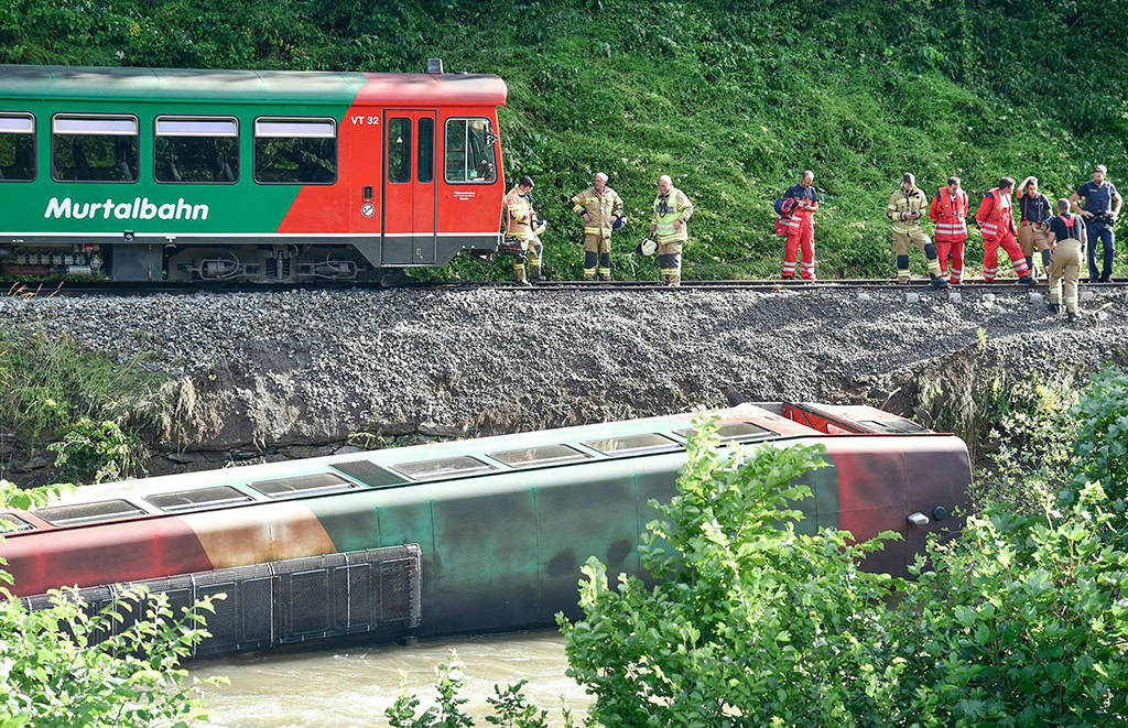 Zug stürzt in die Mur: Österreichische Rettungskräfte vor Ort (Bild: Franz Neumayr/APA/AFP)