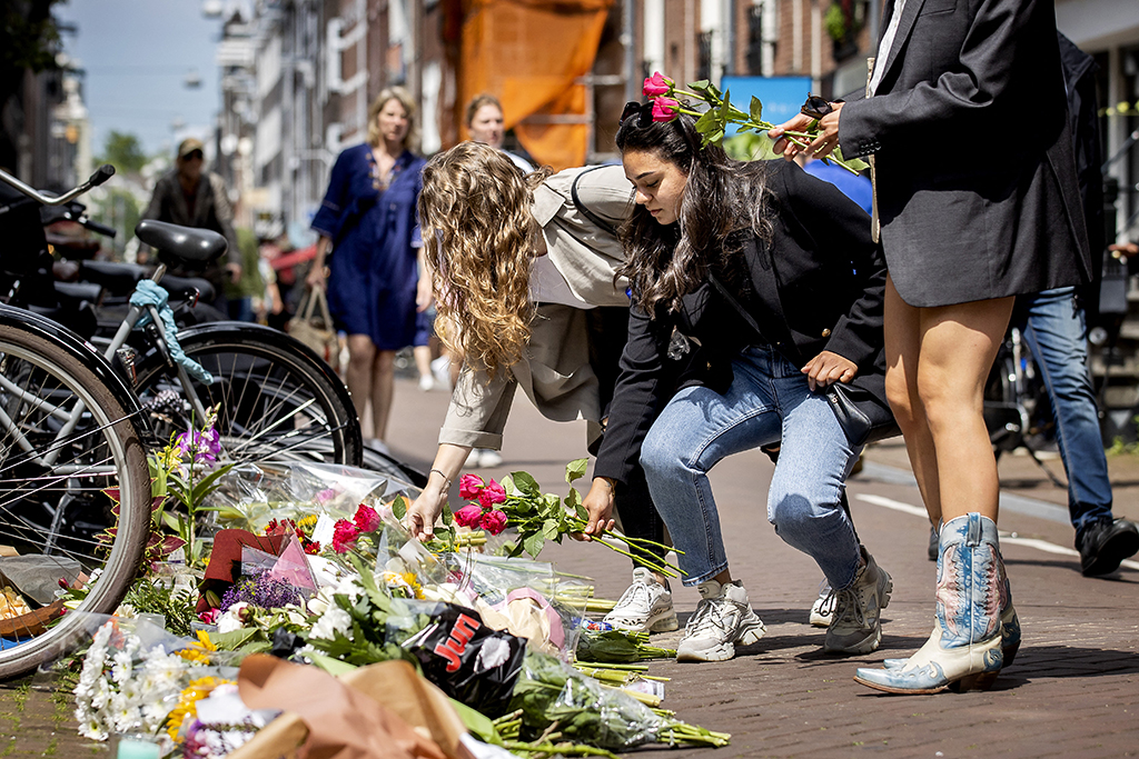 Passanten legen Blumen für Peter R. de Vries am Tatort ab (Bild: Koen van Weel/AFP)