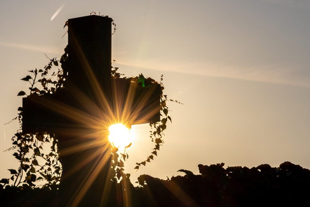 Grabkreuz auf einem Friedhof beim Sonnenuntergang (Bild: © PantherMedia/Christian Feldhaar)