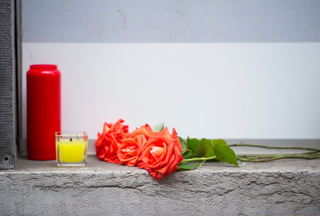 Blumen und Kerzen in Gedenken an Verstorbene