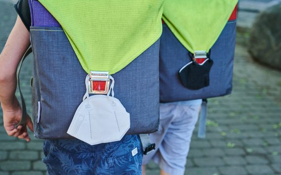Mundnasenschutz hängt am Schulranzen (Bild: Annette Riedl/DPA)