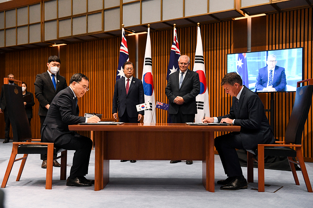Australiens Premierminister Scott Morrison (2. von rechts) und der Südkoreas Präsident Moon Jae-in (2. von links) beobachten, wie der südkoreanische Handelsminister Yeo Han-koo (li.) und der australische Energieminister Angus Taylor das Abkommen unterzeichnen (Bild: Lukas Coch/Pool/AFP)