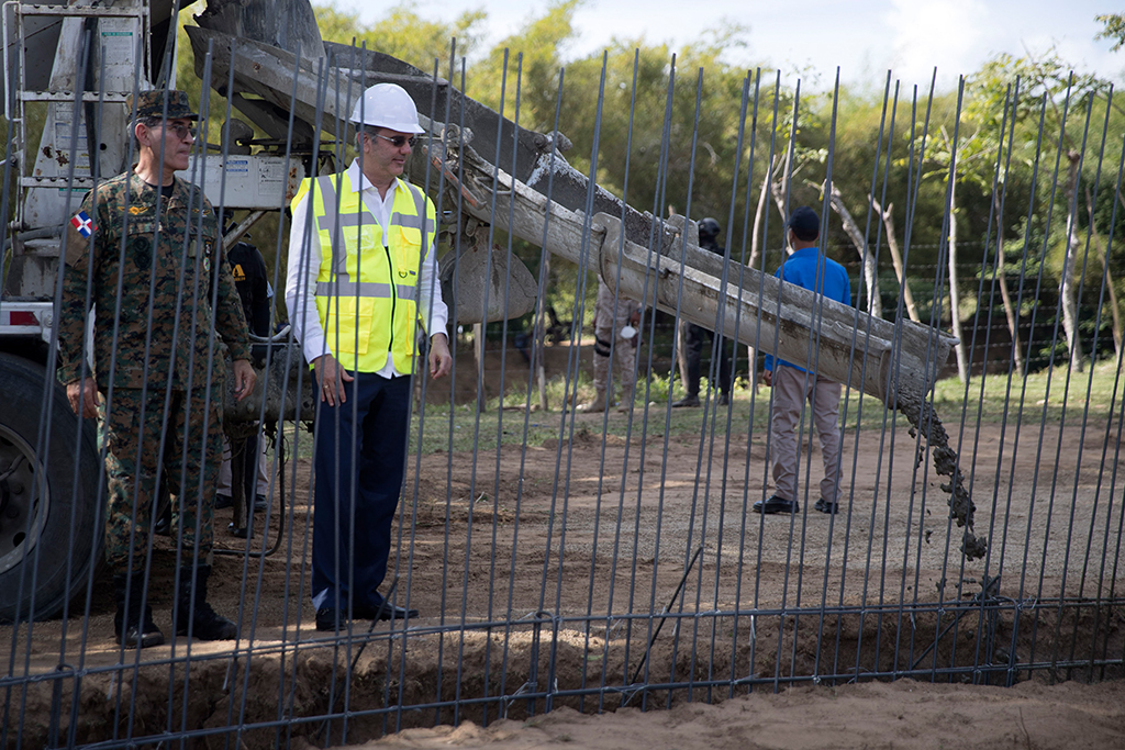 Der dominikanische Präsident Luis Abinader (re.) und Verteidigungsminister Carlos Diaz Morfa beobachten den Beginn der Arbeiten zur Errichtung der Grenzmauer (Bild: Erika Santelices/AFP)