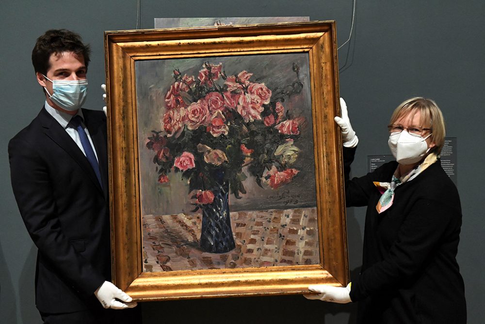 Staatssekretär Thomas Dermine und Imke Gielen, die Anwältin der Familie, mit dem Kunstwerk " Blumenstilleben" (Bild: John Thsy/AFP)
