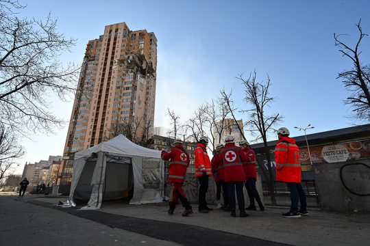 Rettungskräfte vor dem Appartementhaus in Kiew, in das eine Rakete eingeschlagen ist (Bild: Genya Savilov/AFP)