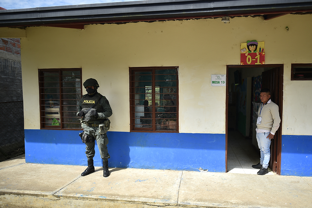 Polizeibeamter vor einem Wahllokal in Toribio, Kolumbien (Bild: Luis Robayo/AFP)