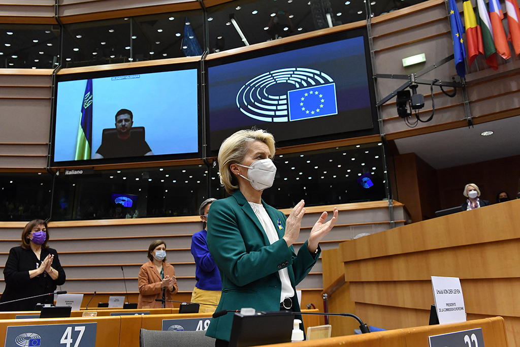 EU-Kommissionspräsidentin von der Leyen im Europaparlament, im Hintergrund auf der Großbildleinwand ist der ukrainische Präsident Selenskyi zu sehen (Bild: John Thys/AFP)