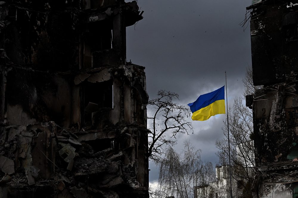 Ukrainische Flagge weht zwischen zerstörten Gebäuden in Borodjanka in der Region Kiew (Illustrationsbild: Sergei Supinsky/AFP)