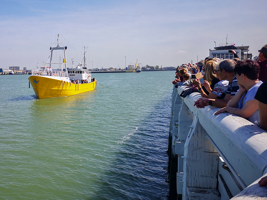 Boot mit der Urne von Arno fährt in Ostende an den Menschen vorbei (Bild: Linde Walters/Belga)