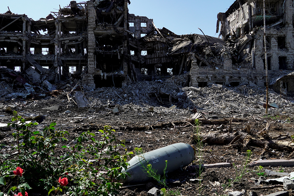Eine nicht explodierte Fliegerbombe vor einem völlig zerstörten Häuserblock in der ukrainischen Stadt Mariupol (Bild: Stringer/AFP)