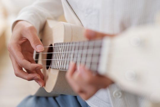Frau spielt ein Lied auf Ukulele