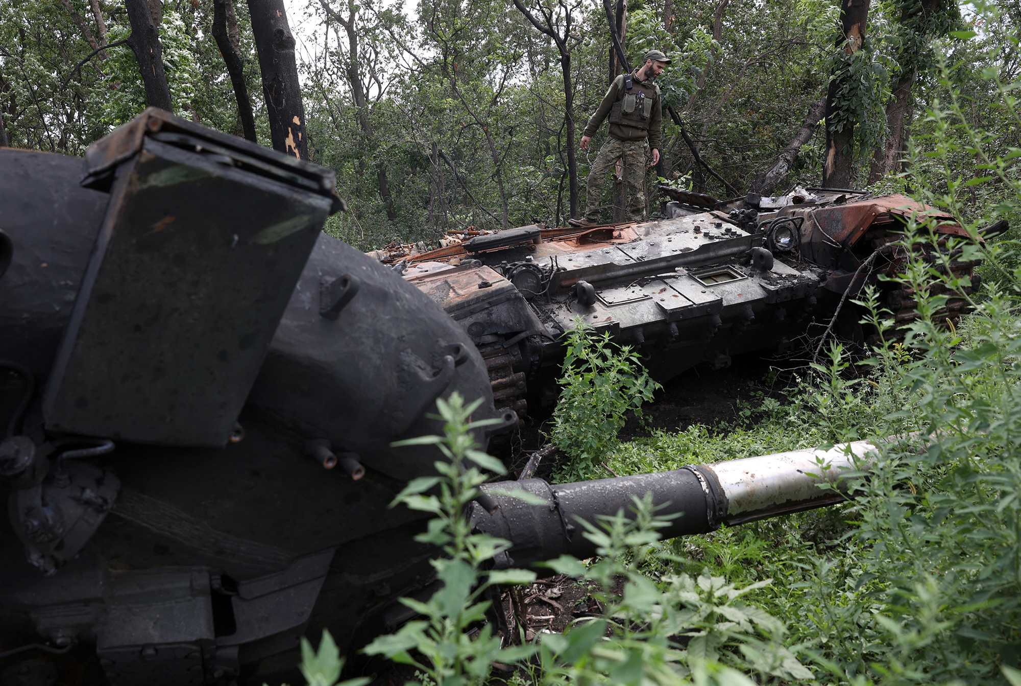 Ukrainischer Soldat auf einem zerstörten russischen Panzer in der Region Charkiw am 23. Juli (Bild: Anatolii Stepanov/AFP)