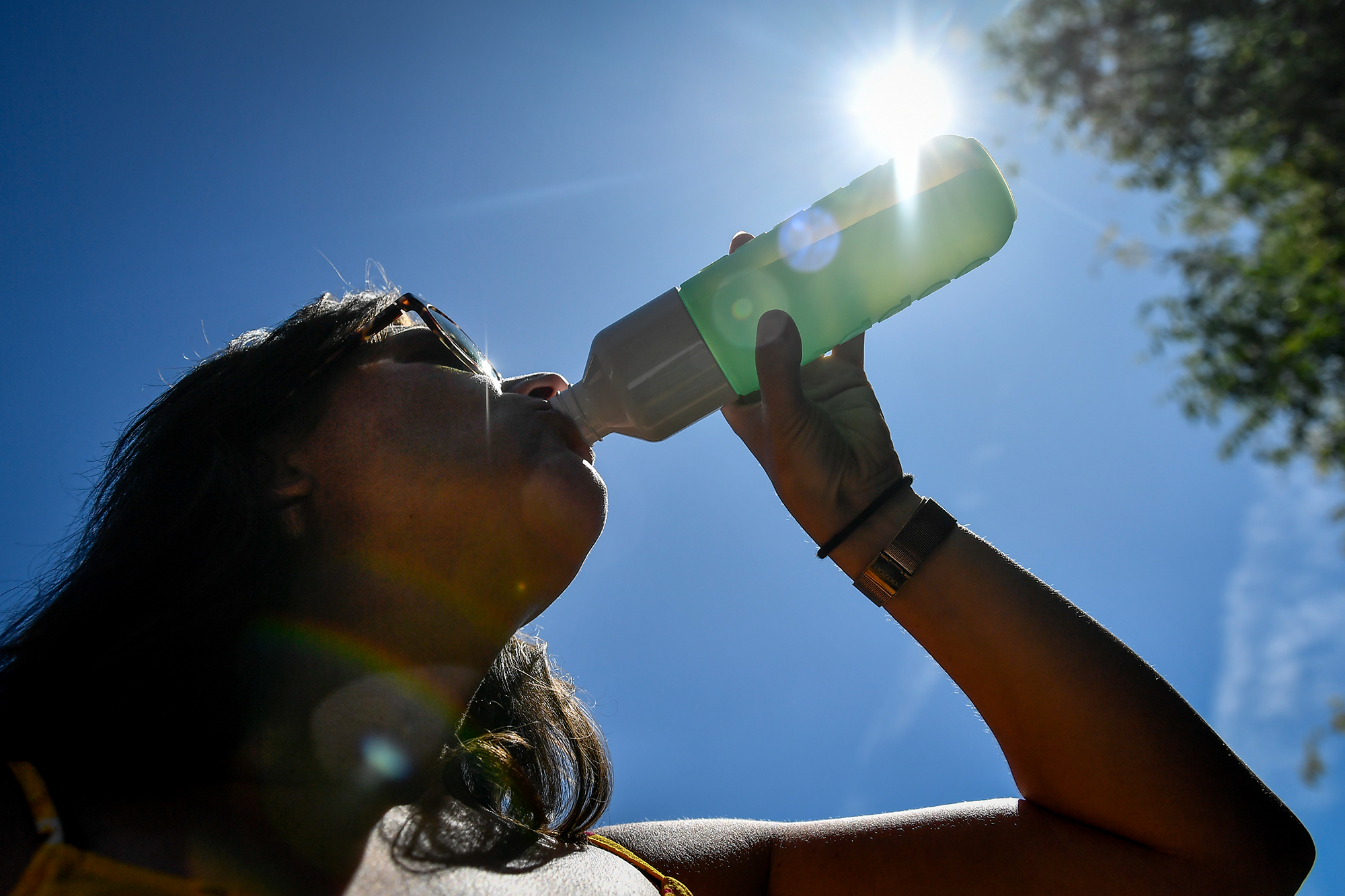Frau trinkt Wasser im Sonnenschein