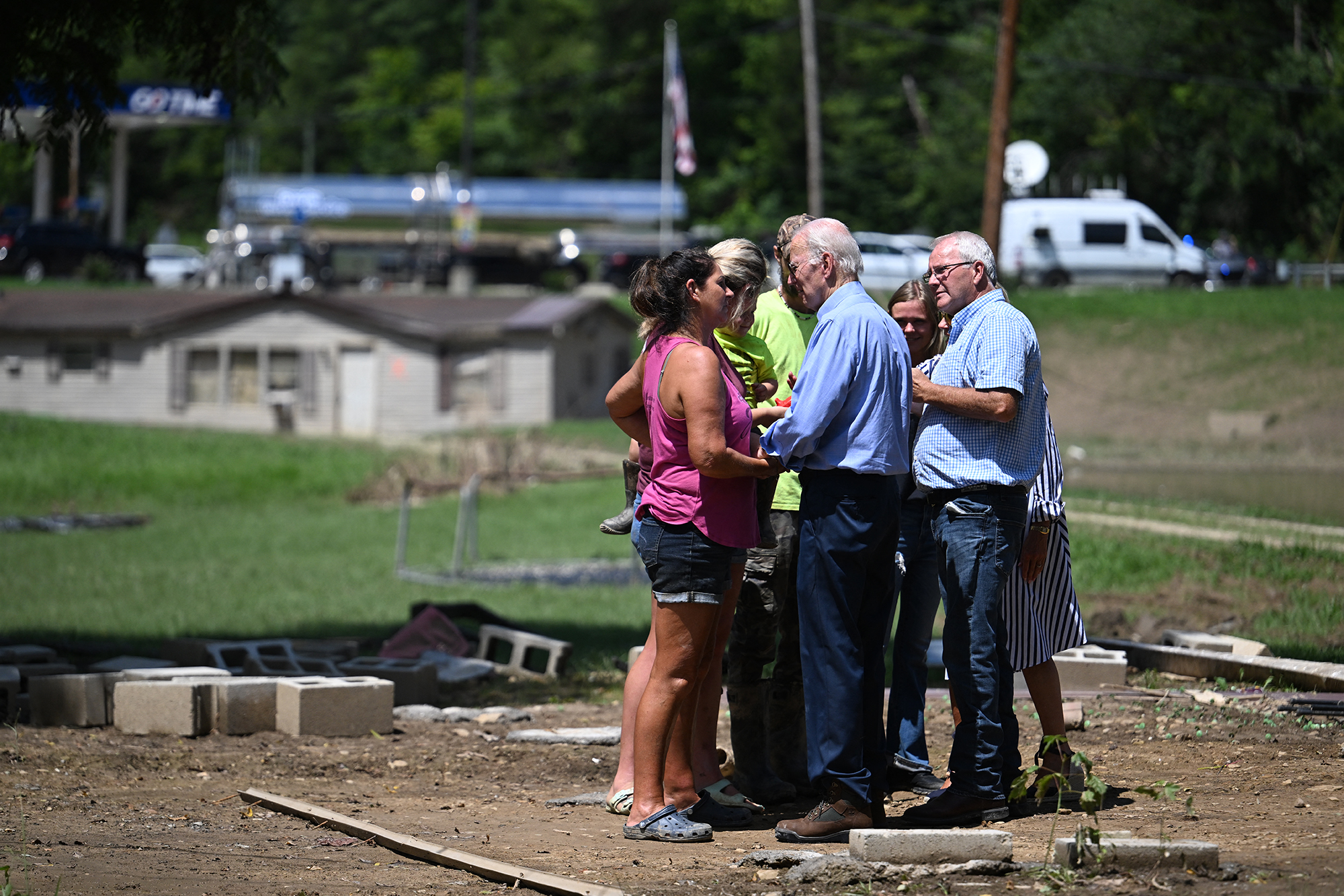 US-Präsident Joe Biden (Mi.) spricht mit einer Familie, die durch die Überschwemmungen ihr Haus verloren hat (Bild: Jim Watson/AFP)