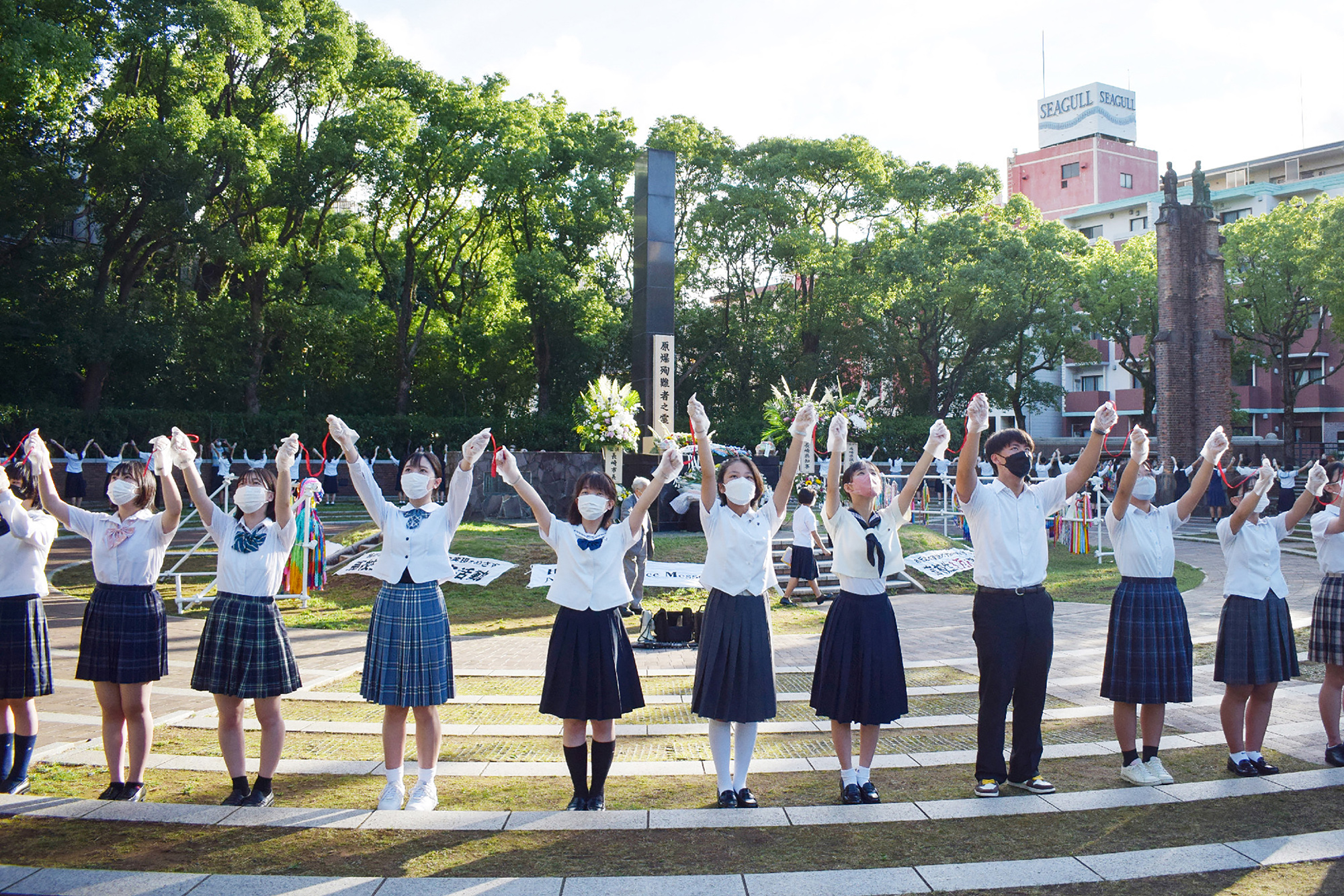 Schüler bilden eine Menschenkette um das Mahnmal in Nagasaki herum (Bild: STR/Jiji Press/AFP)
