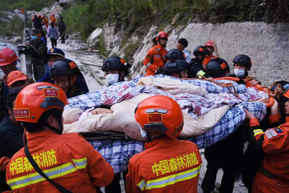 Helfer haben in der Provinz Sichuan eine verletzte Person aus den Trümmern gerettet (Bild: STR/CNS/AFP)