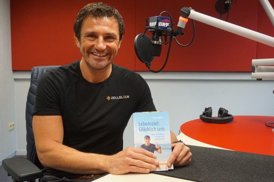 Maik Göbbels mit seinem Ratgeber "Lebensziel: Glücklich sein" (Bild: Stephan Pesch/BRF)