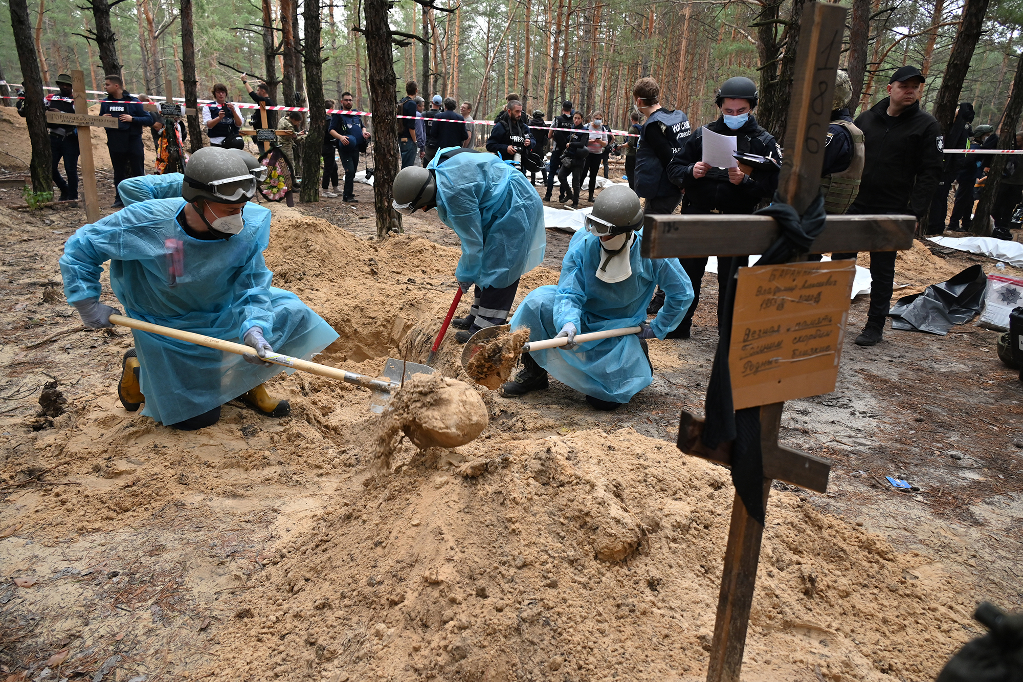 Gerichtsmediziner heben ein Grab in einem Wald am Rande von Izjum in der Ostukraine aus (Bild: Sergey Bobok/AFP)