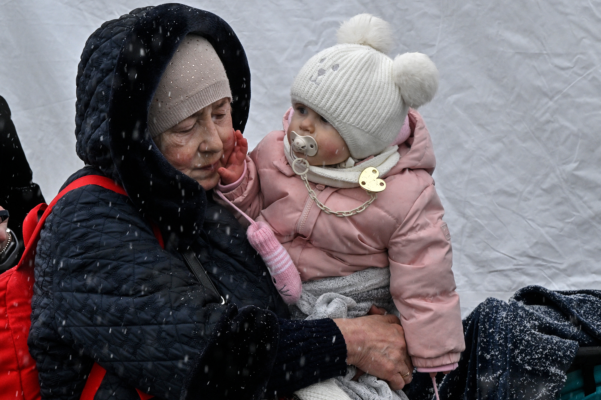 Ukrainische Frau mit Enkeltochter auf der Flucht (Archivbild: Louisa Gouliamaki/AFP)