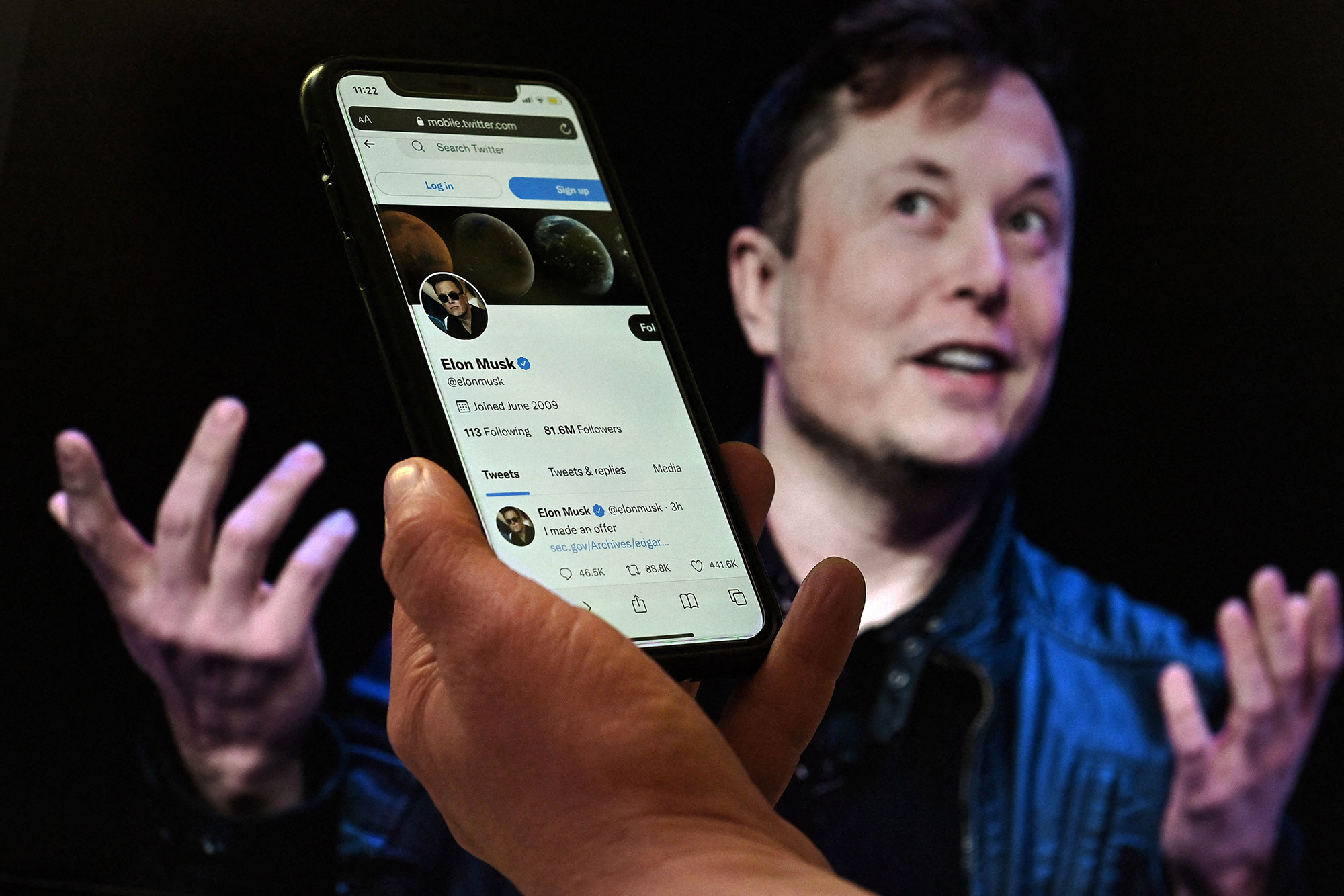 Twitter-Konto von Elon Musk mit einem Foto von ihm im Hintergrund (Bild: Olivier Douliery/AFP)
