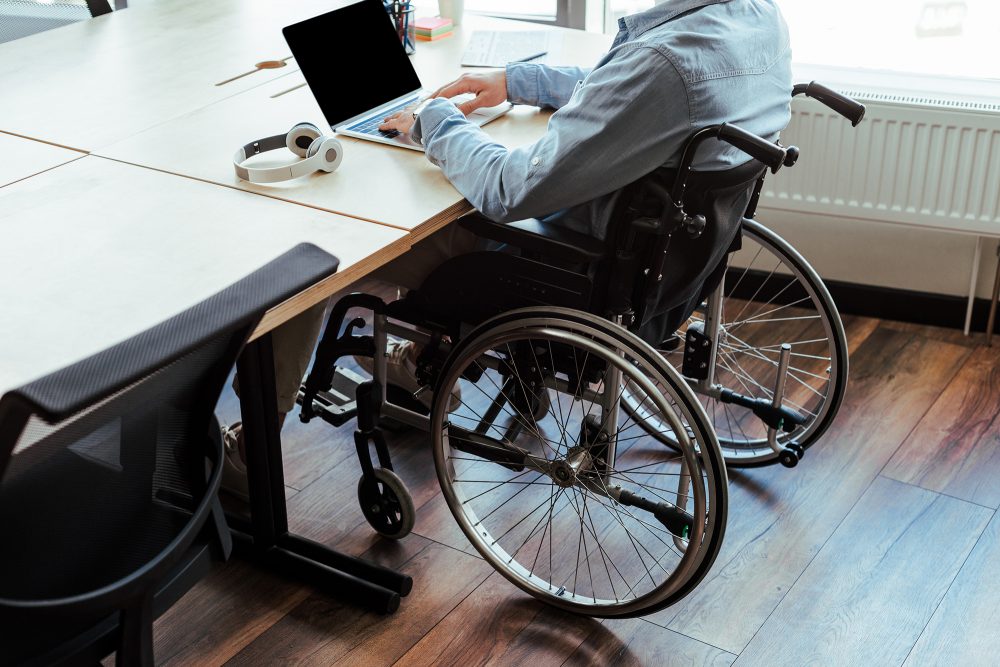 Mann mit Rollstuhl in Büro (Illustrationsbild: © Vitalik Radko/PantherMedia)